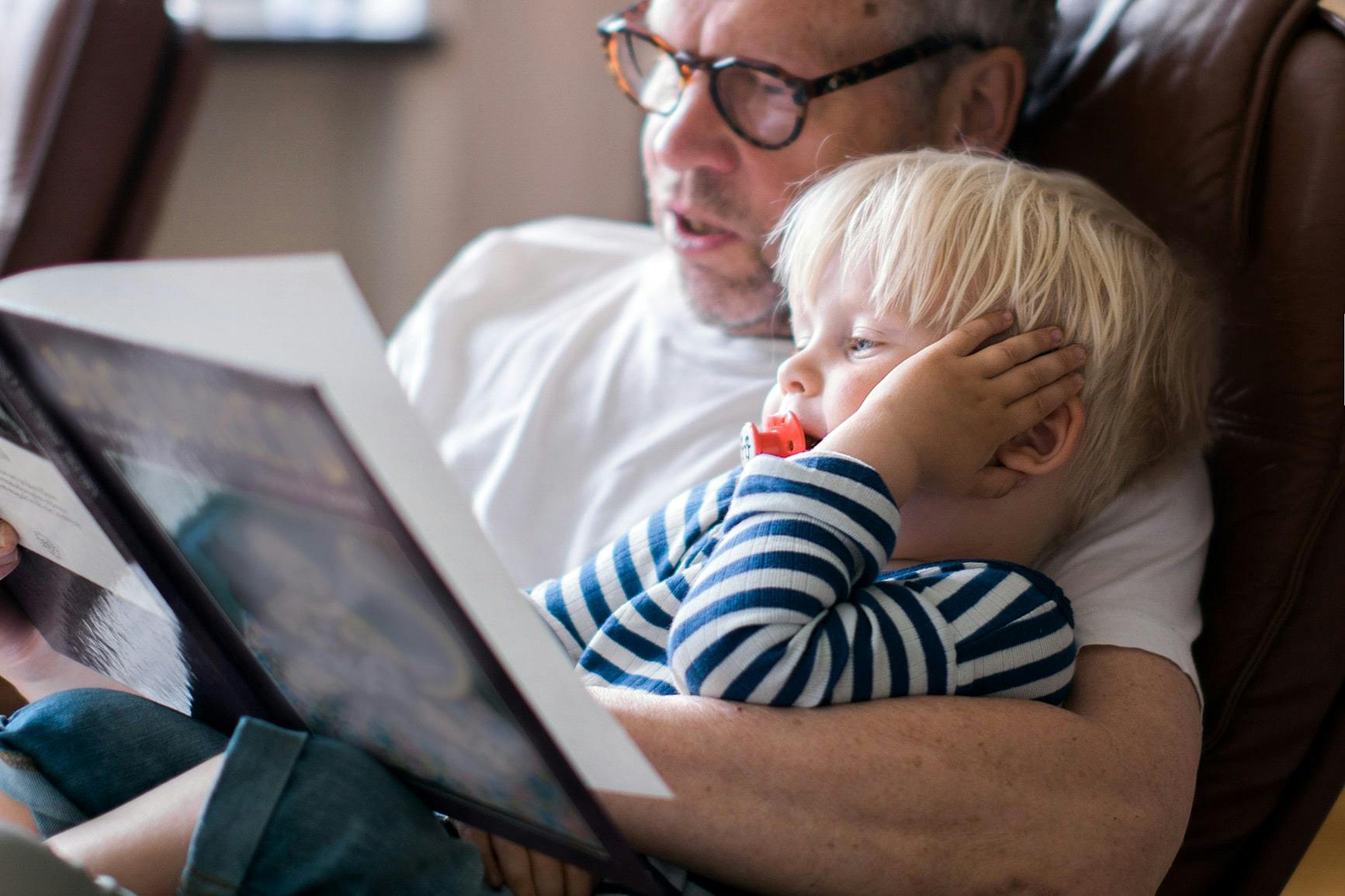 Lege hjem til bestefar og barnebarn, som leser bok mens de venter