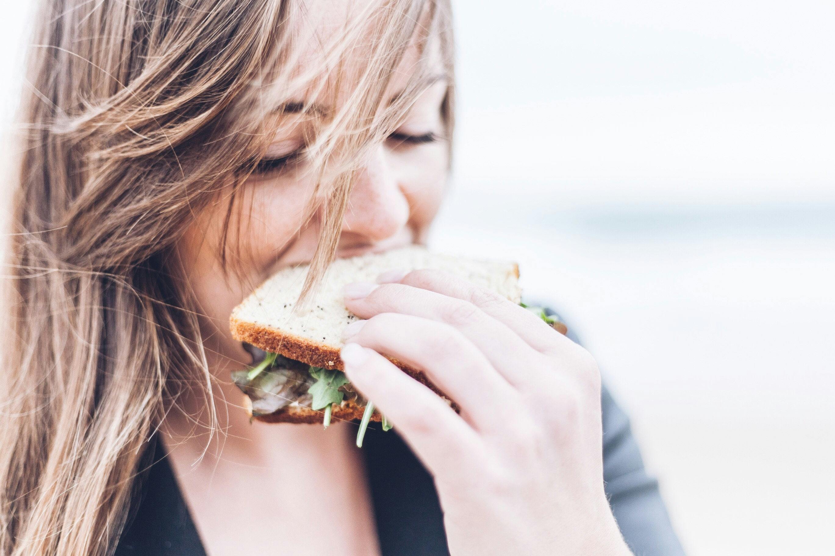 kvinne spiser sandwich